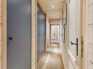 Step into this charming hallway featuring warm, natural wood paneling on the walls and ceiling, creating a cozy and inviting atmosphere.