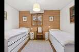 This charming bedroom features two twin beds with ample storage drawers, perfect for maximizing space.