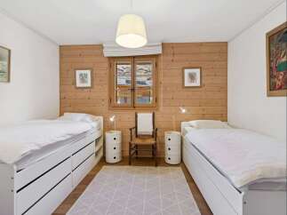 This charming bedroom features two twin beds with ample storage drawers, perfect for maximizing space.