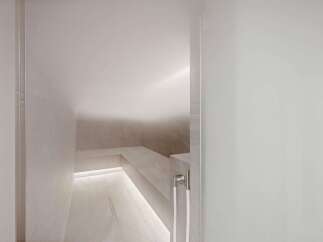 Experience ultimate relaxation in this modern steam room, featuring sleek marble tilework and ambient LED lighting.
