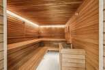 Experience ultimate relaxation in this luxurious wooden sauna, featuring multi-level seating and ambient LED lighting.