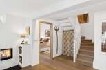 Discover a charming interior featuring a cozy fireplace and a well-lit bedroom accessible through a wooden doorway.