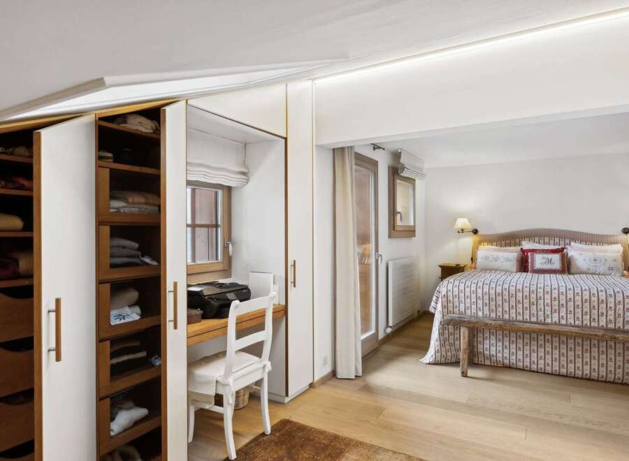 Discover this charming bedroom featuring a built-in wardrobe with ample storage and a convenient desk area by the window.