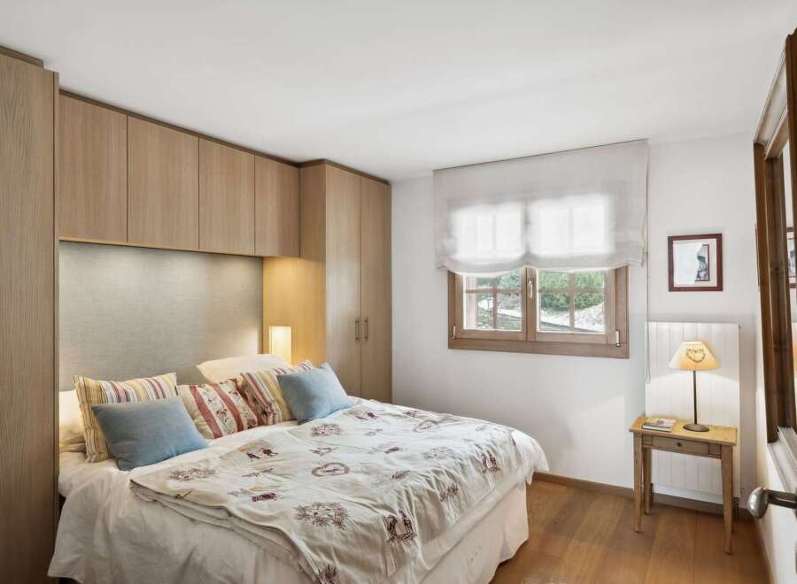 This charming bedroom features a cozy bed adorned with decorative pillows and a patterned duvet, creating a welcoming atmosphere.