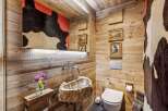 Experience rustic luxury in this unique bathroom featuring a stunning live-edge wood sink and walls clad in warm, natural wood.