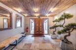 Step into a warm and inviting entryway featuring a rustic wooden ceiling and stone tile flooring.