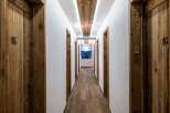 Experience rustic charm and modern convenience in this hotel hallway, featuring beautifully crafted wooden doors with unique numbering.