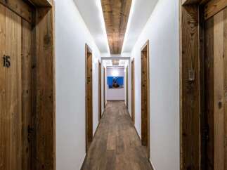 Experience rustic charm and modern convenience in this hotel hallway, featuring beautifully crafted wooden doors with unique numbering.