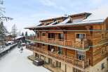 Experience luxury mountain living in this stunning wooden chalet, featuring expansive balconies perfect for enjoying breathtaking winter views.