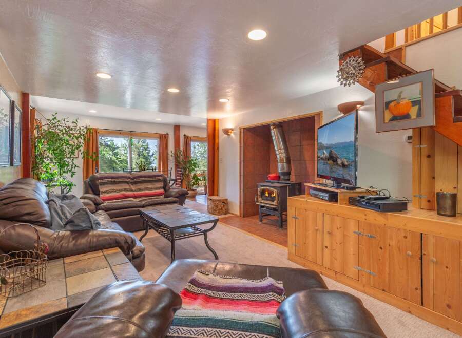 Cozy living room featuring a large leather sectional sofa and a striped sofa, perfect for family gatherings.