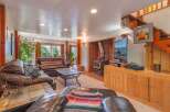 Cozy living room featuring a large leather sectional sofa and a striped sofa, perfect for family gatherings.