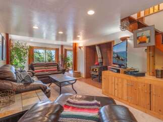 Cozy living room featuring a large leather sectional sofa and a striped sofa, perfect for family gatherings.