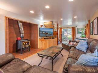 Cozy up by the fire in this inviting living room, featuring a rustic wood-burning stove set against a warm tile backdrop.