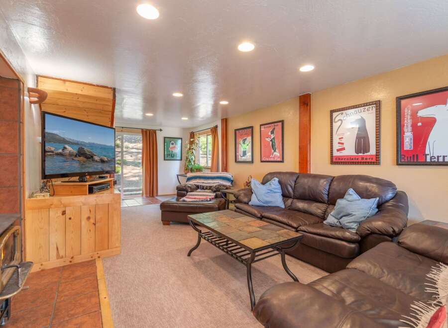 Cozy up by the fireplace in this inviting living room, featuring a large leather sectional sofa perfect for family gatherings.