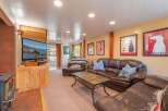 Cozy up by the fireplace in this inviting living room, featuring a large leather sectional sofa perfect for family gatherings.
