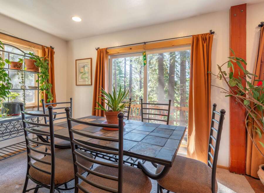 Enjoy meals with a view in this charming dining room, featuring a tile-top dining table and comfortable seating.