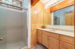 This bathroom features a spacious walk-in shower with a glass door and a light-colored speckled wall.