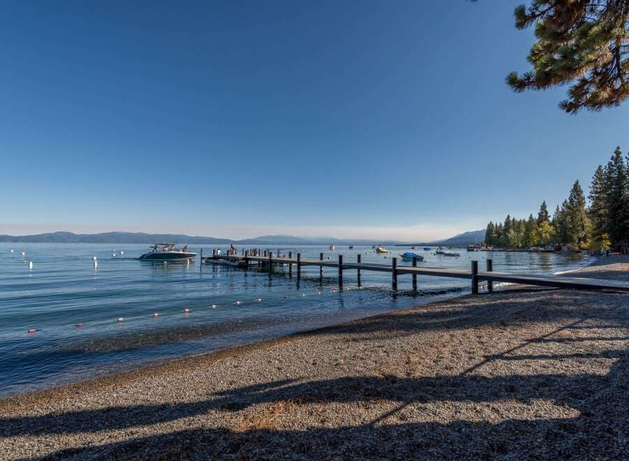Experience lakeside luxury with this stunning property featuring a private dock and a serene beach area.