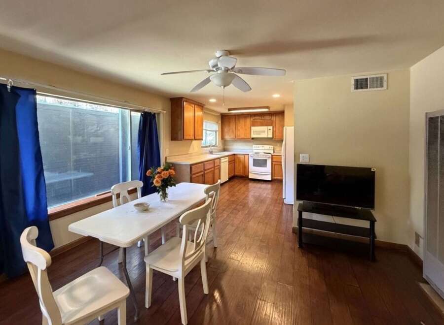 This charming dining and kitchen area features a spacious dining table with four chairs, perfect for family meals.