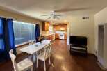 This charming dining and kitchen area features a spacious dining table with four chairs, perfect for family meals.