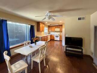 This charming dining and kitchen area features a spacious dining table with four chairs, perfect for family meals.