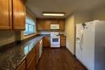 Discover this charming kitchen featuring warm wooden cabinetry and elegant granite countertops.