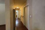 This hallway features warm hardwood floors and neutral-toned walls, creating a welcoming atmosphere.