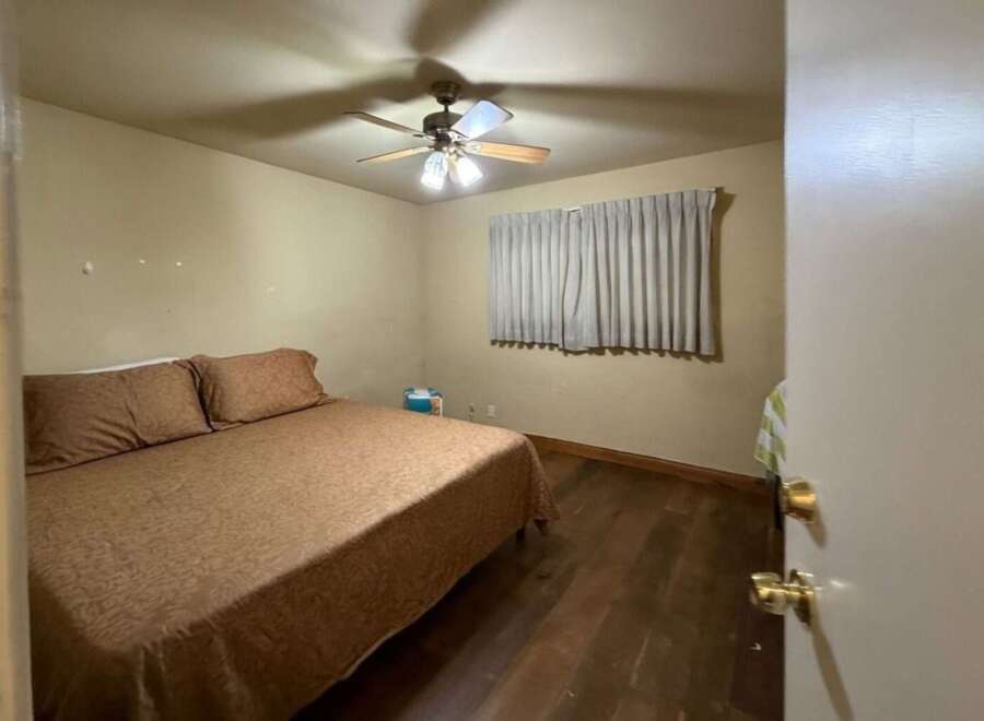 Discover this cozy bedroom featuring a comfortable bed with a patterned comforter and two plush pillows.