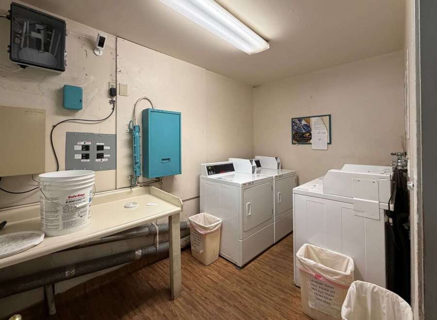 Discover convenience in this well-equipped laundry room, featuring multiple washers and dryers ready for use.