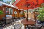 Enjoy outdoor living with this charming patio featuring a spacious grill and a round wooden dining table perfect for al fresco meals.