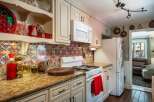 This charming kitchen features a vibrant, patterned backsplash that adds a pop of color to the cream-colored cabinetry.