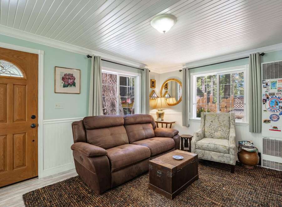 Step into this cozy living room featuring a plush brown sofa and a charming armchair, perfect for relaxing.