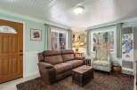 Step into this cozy living room featuring a plush brown sofa and a charming armchair, perfect for relaxing.