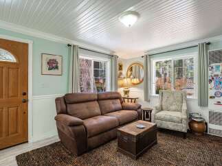 Step into this cozy living room featuring a plush brown sofa and a charming armchair, perfect for relaxing.
