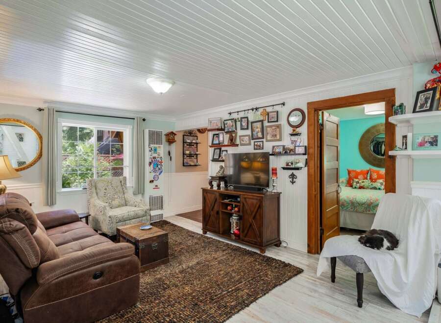 Step into this charming living room, featuring a comfortable brown recliner sofa and a decorative armchair perfect for relaxation.