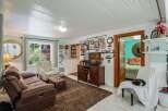 Step into this charming living room, featuring a comfortable brown recliner sofa and a decorative armchair perfect for relaxation.