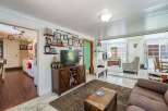 Step into this charming living room, featuring a cozy entertainment center adorned with family photos and a large television.