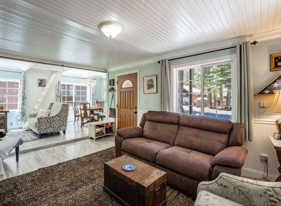 Step into this inviting living space featuring a comfortable brown leather sofa and a decorative trunk coffee table, perfect for cozy gatherings.
