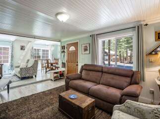 Step into this inviting living space featuring a comfortable brown leather sofa and a decorative trunk coffee table, perfect for cozy gatherings.