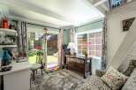Step into this charming room, bathed in natural light from a large sliding glass door and window, offering a serene view of the backyard.