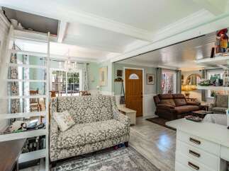 Discover this charming living space featuring a unique lofted area accessible by a ladder, perfect for extra storage or a cozy nook.