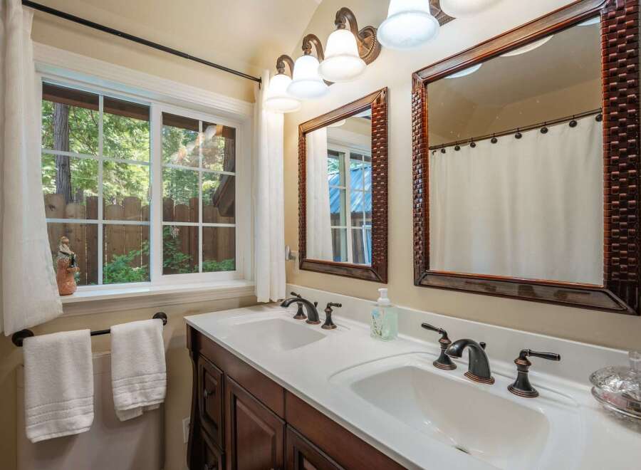 This charming bathroom features a spacious double vanity with elegant bronze fixtures, perfect for busy mornings.