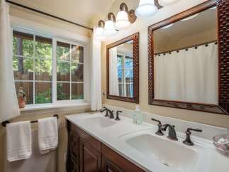 This charming bathroom features a spacious double vanity with elegant bronze fixtures, perfect for busy mornings.