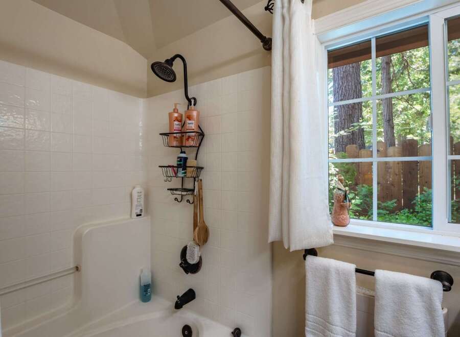 Experience a refreshing shower in this bathroom featuring a tiled tub and shower surround.