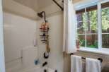 Experience a refreshing shower in this bathroom featuring a tiled tub and shower surround.