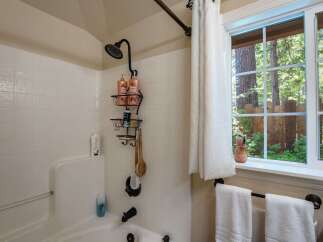 Experience a refreshing shower in this bathroom featuring a tiled tub and shower surround.