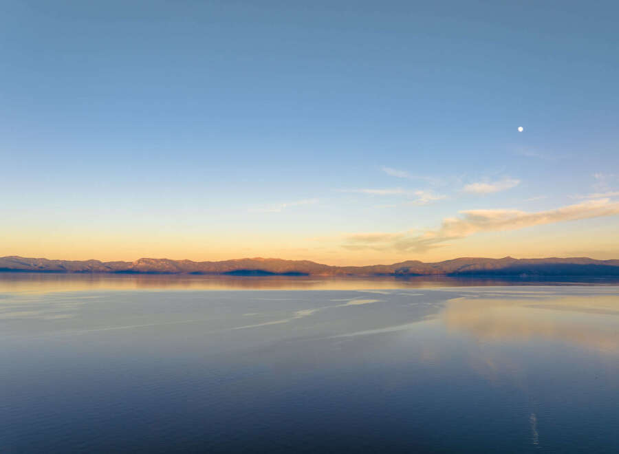 Experience breathtaking sunset views over a serene lake, with majestic mountains forming a stunning backdrop.