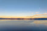 Experience breathtaking sunset views over a serene lake, with majestic mountains forming a stunning backdrop.