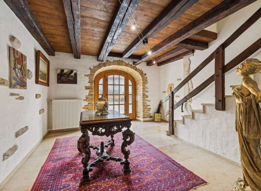 Step into this charming entryway featuring rustic wooden beams and exposed stone accents, creating a warm and inviting atmosphere.