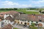 Discover this charming property featuring a classic tiled roof and traditional shutters, set against a backdrop of picturesque green fields and rolling hills.